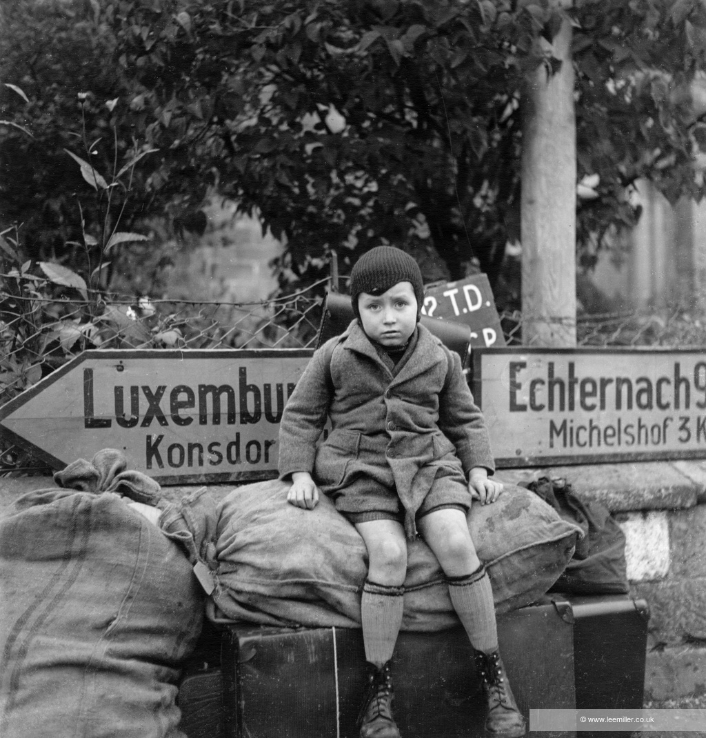 Copyright LeeMillerArchives Small tired boy Raymond Melchers aged 7 waits at cross roads for transport Bech Luxembourg 1945